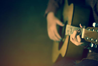 Midsection of man playing guitar