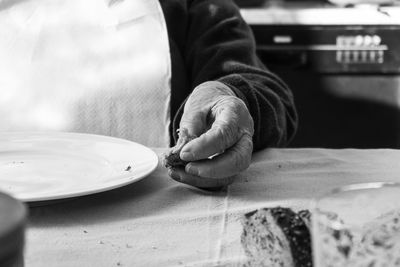 Midsection of woman having food at table