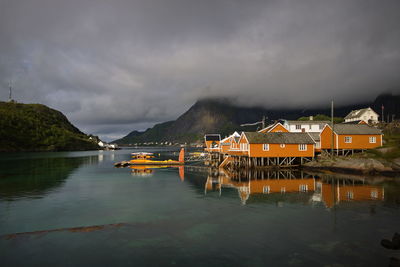 Scenic view of lake by buildings against sky