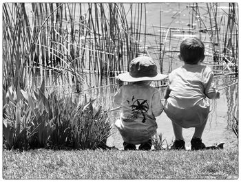 Rear view of boy and daughter on plants