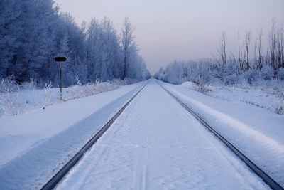 Snow covered road against clear sky