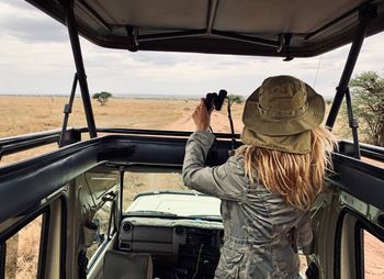 Woman standing in car during safari