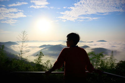 Side view of young man standing against sky during sunset