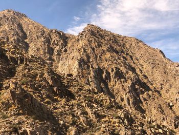 Low angle view of rocky mountains against sky