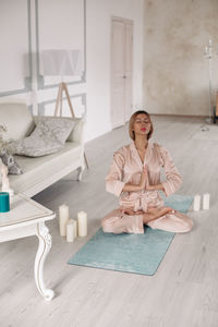 Portrait of smiling woman sitting on floor at home