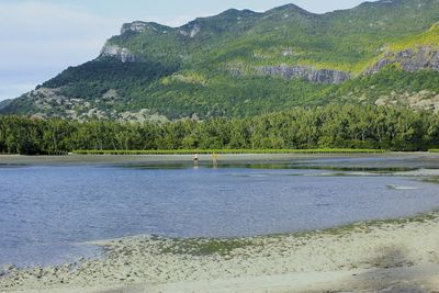 Scenic view of lake against green mountains