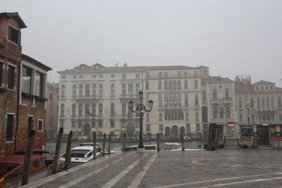 Street by buildings against sky in city