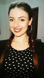 Portrait of smiling young woman standing at home