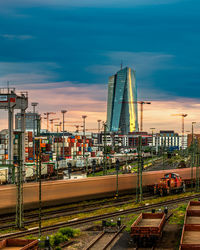 Train in city against sky at sunset