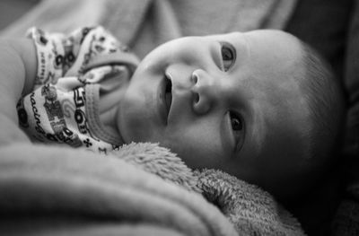 Close-up portrait of cute baby lying on bed