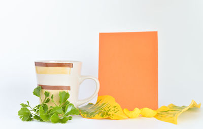 Close-up of coffee cup on table against white background