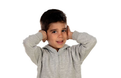 Portrait of smiling boy standing against white background