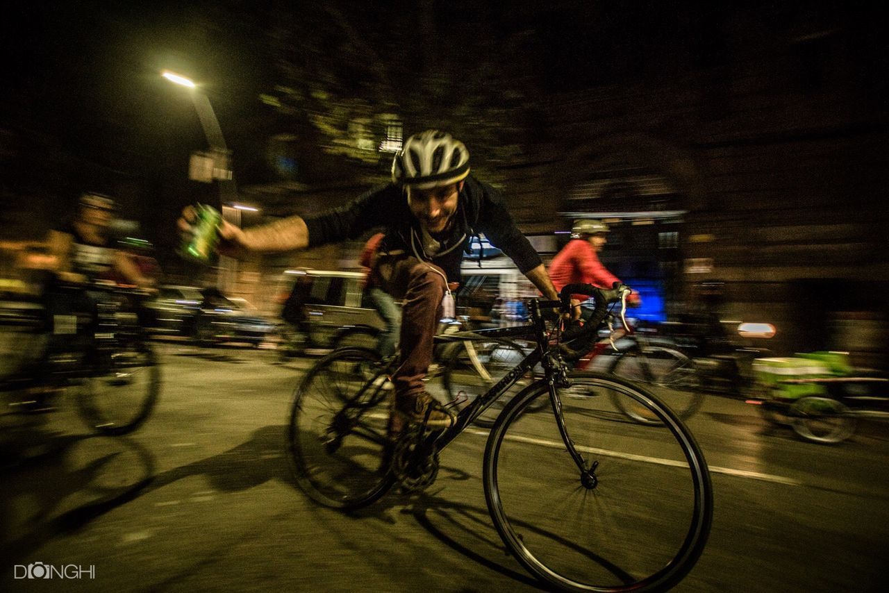 mode of transport, transportation, land vehicle, night, illuminated, bicycle, riding, on the move, street, road, travel, motion, city, men, blurred motion, city life, city street, built structure, car, speed, building exterior, architecture, person, outdoors, rush hour