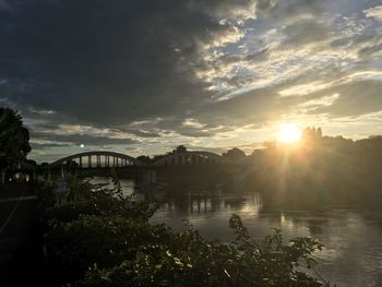Bridge over river against sky during sunset