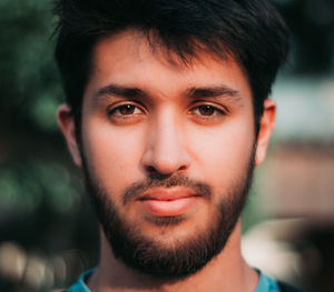 Close-up portrait of young man with hunny brown eyes and beard