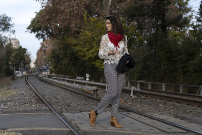 Young woman standing on railroad track