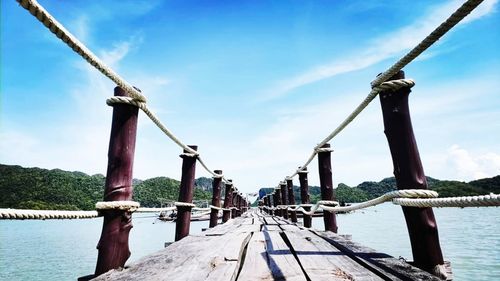 Low angle view of pier over sea against sky