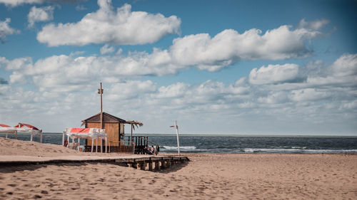 Lifeguard hut on beach against sky