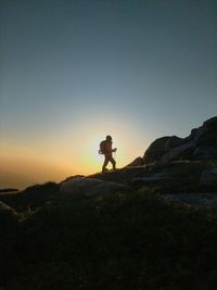 Hiker walking on mountain during sunset