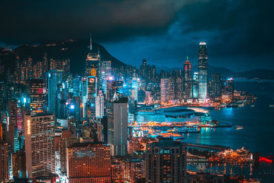 Illuminated buildings in city against sky at night