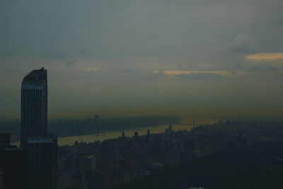 Buildings in city against sky at sunset