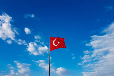 Low angle view of flag against blue sky