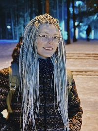 Portrait of young woman standing on road