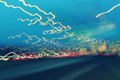 Light trails against blue sky at night