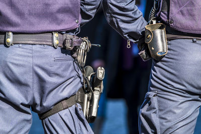 Rear view midsection of police with weapons