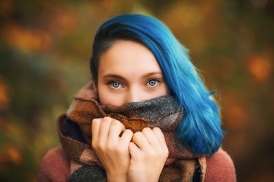 Close-up portrait of young woman with dyed hair wearing scarf