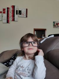 Portrait of boy sitting on sofa at home