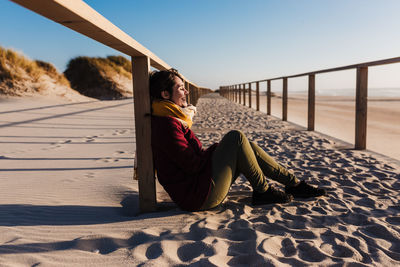 Young woman with eyes closed relaxing at beach at sunset. holidays and relaxation concept