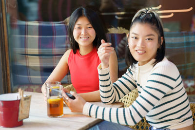 Portrait of smiling friends sitting at home