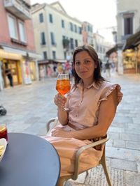 Portrait of young woman drinking drink in restaurant