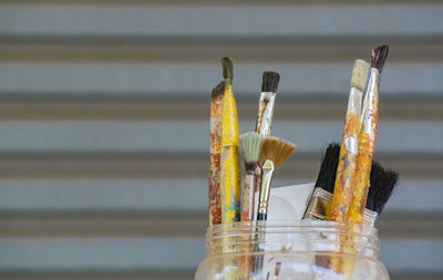 Close-up of paintbrushes on glass table