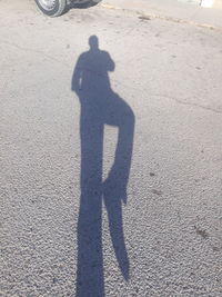 Shadow of man on road