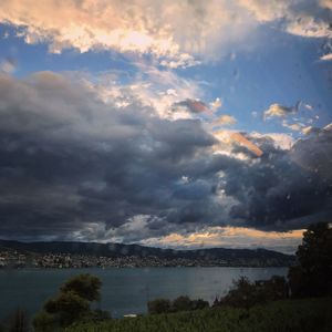 Scenic view of river against cloudy sky