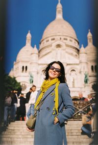 Young woman standing against historic building