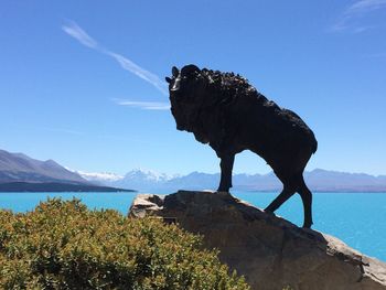Low angle view of statue of rock against lake pukaki