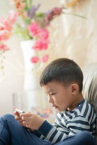 Boy looking at mobile phone at home