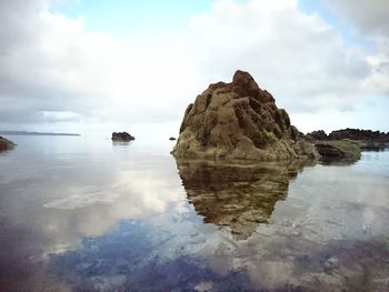 Rocks in sea against sky