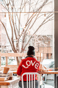 Rear view of woman standing against window