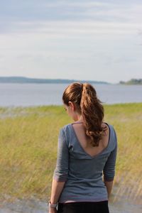 Rear view of woman looking at sea against sky