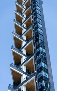 Low angle view of modern buildings against clear blue sky