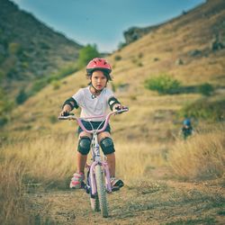 Portrait of boy riding bicycle on field