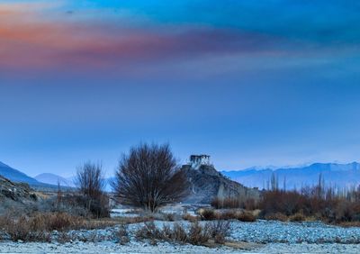 Scenic view of snowcapped field against sky during winter