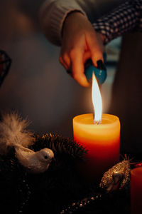 Midsection of woman and a child holding lit candle