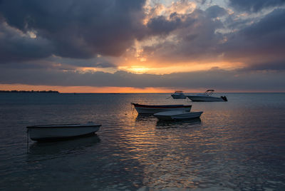 Boat in sea against sky during sunset
