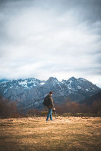 Rear view of woman on snowcapped mountain against sky