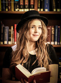 Portrait of young woman reading book